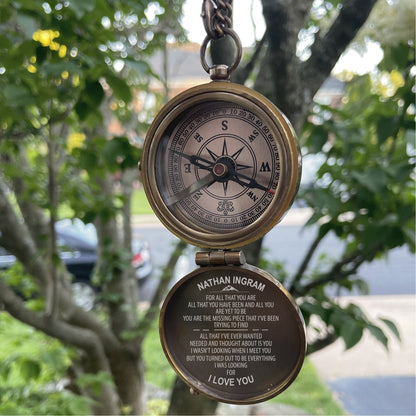 May include: A brass-toned pocket compass with a hinged lid. The compass face features black cardinal directions and degree markings. The interior of the lid is engraved with the text: NATHAN INGRAM, FOR ALL THAT YOU ARE, ALL THAT YOU HAVE BEEN AND ALL YOU ARE YET TO BE, YOU ARE THE MISSING PIECE THAT I'VE BEEN TRYING TO FIND, ALL THAT I'VE EVER WANTED, NEEDED AND THOUGHT ABOUT IS YOU, I WASN'T LOOKING WHEN I MET YOU, BUT YOU TURNED OUT TO BE EVERYTHING I WAS LOOKING FOR, I LOVE YOU.
