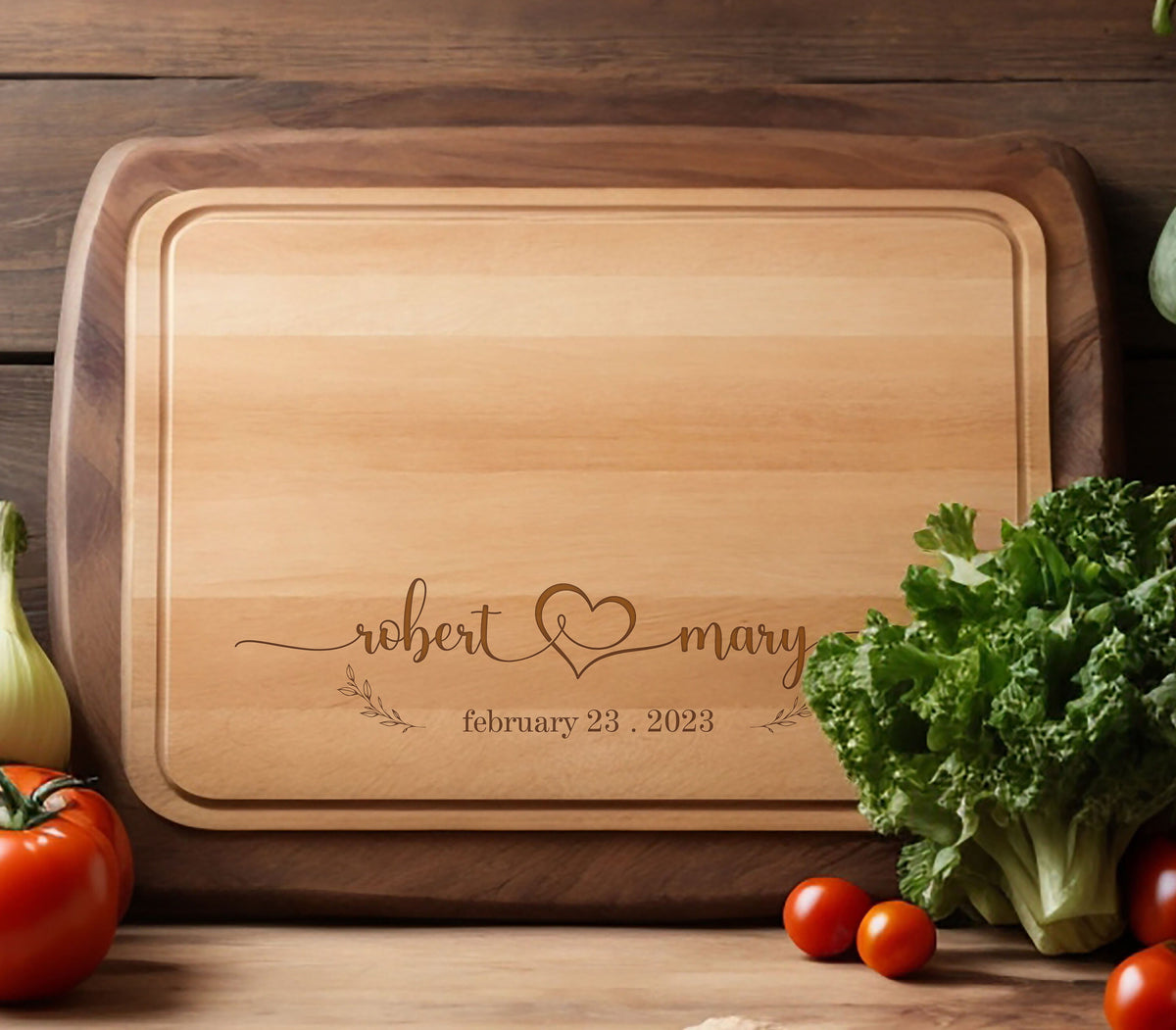 May include: A wooden cutting board with a walnut edge and a maple center. The board is engraved with the names "robert & mary" and the date "february 23, 2023".
