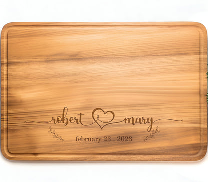 May include: Personalized wooden cutting board with the names "robert & mary" and the date "february 23, 2023" engraved on it.