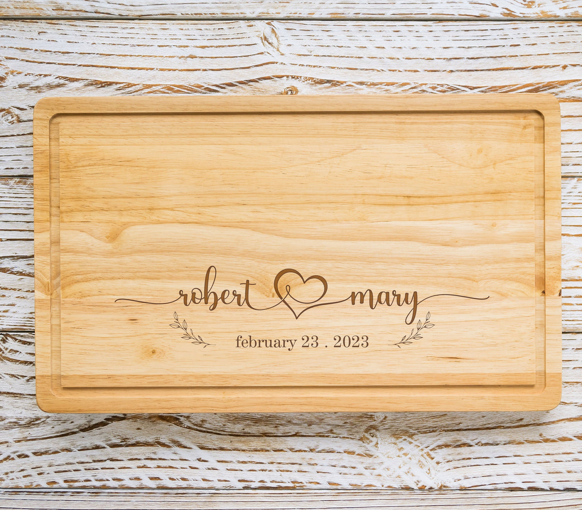 May include: A wooden cutting board with the text "robert & mary" and a heart symbol, along with the date "february 23, 2023".