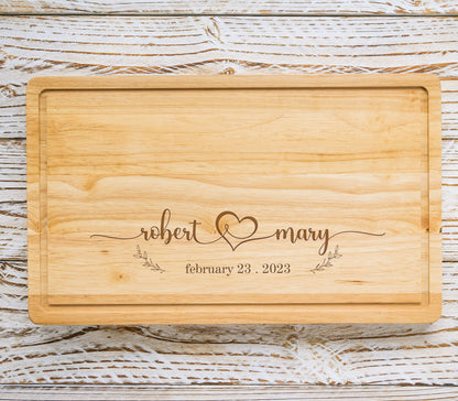 May include: A wooden cutting board with the text "robert & mary" and a heart symbol, along with the date "february 23, 2023".