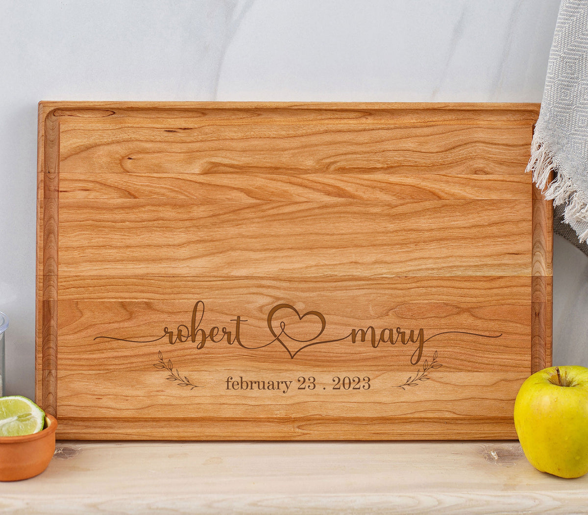 May include: A wooden cutting board with a personalized inscription. The inscription reads "robert & mary february 23, 2023" with a heart symbol between the names.