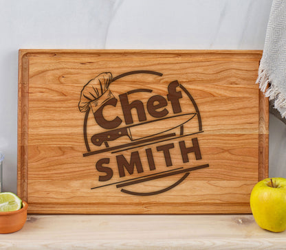 May include: A wooden cutting board with a brown engraved design that says "Chef SMITH" with a chef's hat and knife graphic.