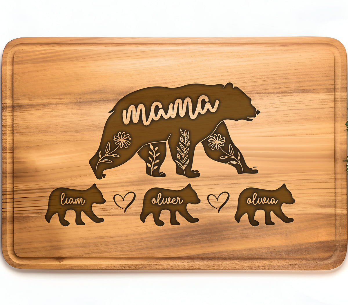 May include: A rectangular wooden cutting board with a bear design. The word "mama" is carved into the bear's body, with floral accents. Below are three smaller bear figures with the names "liam", "oliver", and "olivia".