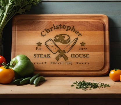 May include: Personalized wooden cutting board with the text "Christopher Steak House Est. 2022 King of BBQ" and a graphic of crossed butcher knives and a steak.