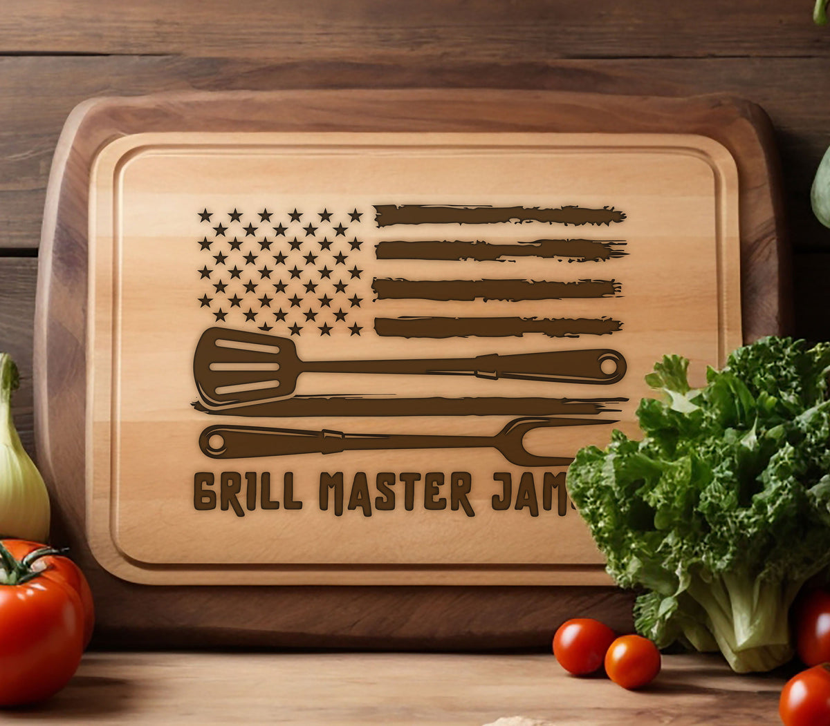 May include: A wooden cutting board with a brown wood frame and a light wood surface. The board features a distressed American flag design with a spatula, knife, and fork. The text "Grill Master Jam" is printed below the flag.