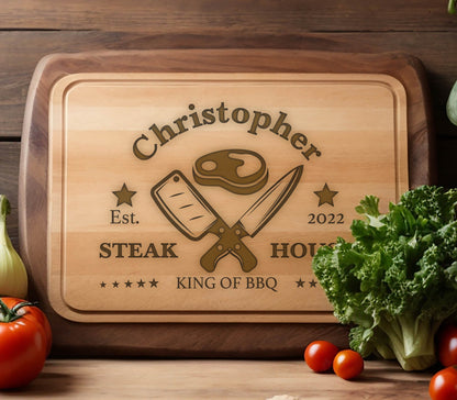 May include: Personalized wooden cutting board with the text "Christopher Steak House Est. 2022 King of BBQ" and a graphic of crossed butcher knives and a steak.