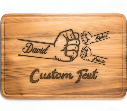 May include: A wooden cutting board with a design of three fists bumping each other. The names "David", "Patricia", and "Richard" are engraved on the fists. The text "Custom Text" is also engraved on the board.