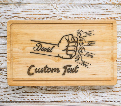 May include: A wooden cutting board with a design of five fists, each with a name written on it: David, Susan, Richard, Patricia, and Thomas. The text "Custom Text" is also engraved on the board.