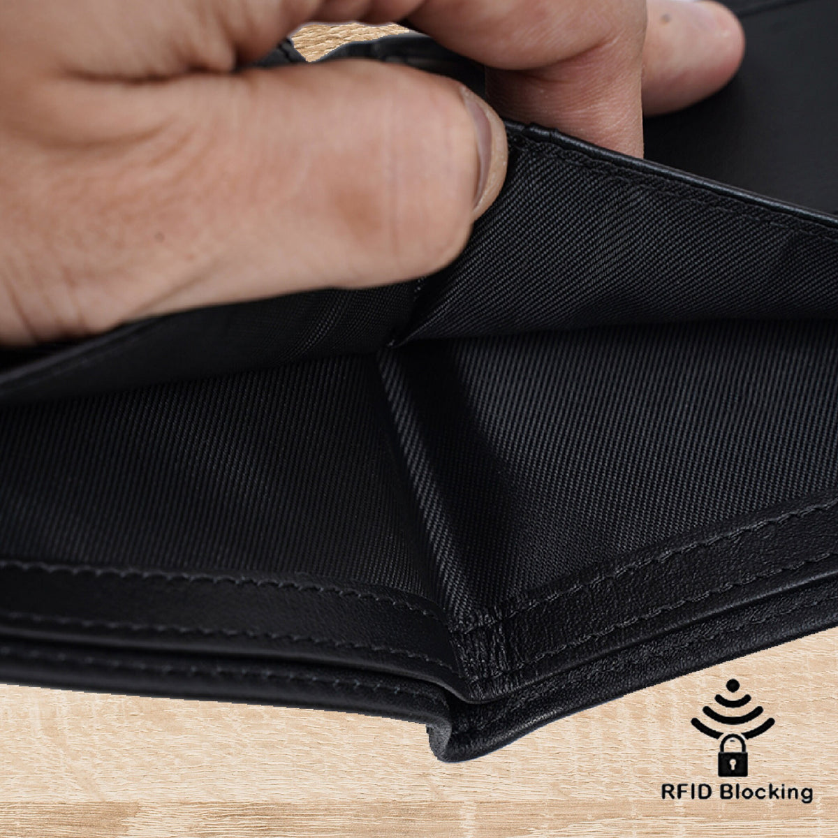 May include: A black bifold wallet featuring a smooth leather exterior and a textured fabric interior lining. The wallet includes an RFID blocking feature, indicated by a small icon and the text RFID Blocking printed in the bottom right corner.