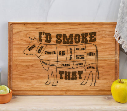 May include: A wooden cutting board with a cow silhouette and the text "I'D SMOKE THAT". The cow is divided into different cuts of meat, including head, neck, chuck, rib, short loin, sirloin, bottom sirloin, round, brisket, shank, plate, flank, and shank.