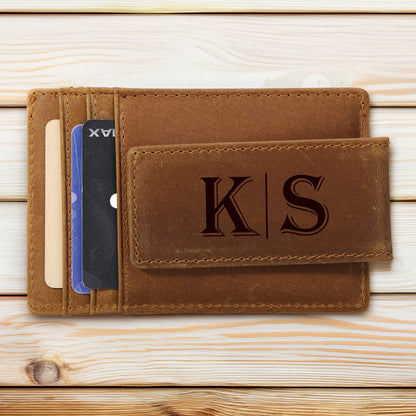 May include: A brown leather wallet with a magnetic money clip. The wallet is open, revealing several credit cards. The money clip is embossed with the initials "KS". The wallet is made of a distressed leather material.