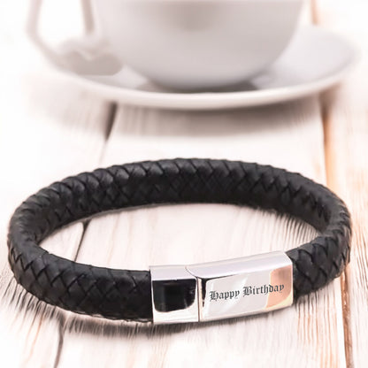 May include: Black leather bracelet with a silver clasp and the inscription "Happy Birthday".