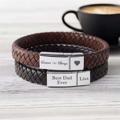 May include: Two leather bracelets with silver clasps. The top bracelet is brown and has the text "Forever ∞ Always" engraved on the clasp. The bottom bracelet is black and has the text "Best Dad Ever" and "Lisa" engraved on the clasp.