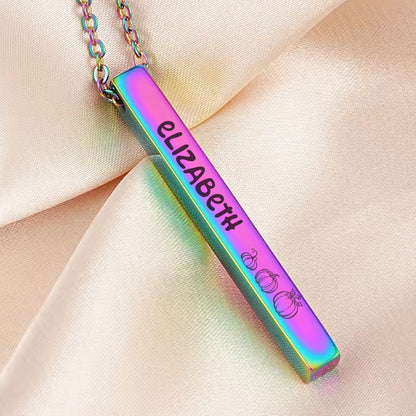 May include: A rainbow iridescent bar necklace with the name "Elizabeth" engraved on it and a small pumpkin design at the bottom.