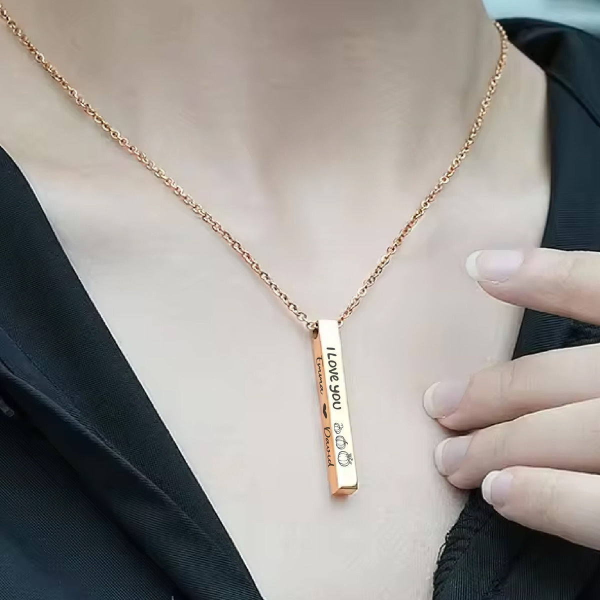 May include: A gold necklace with a vertical bar pendant that has the words "I Love You" engraved on it. The pendant also has a heart and crown symbol engraved on it.