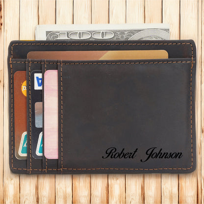 May include: A brown leather wallet with a flap closure and a card slot. The wallet has a personalized inscription that reads "Robert Johnson".