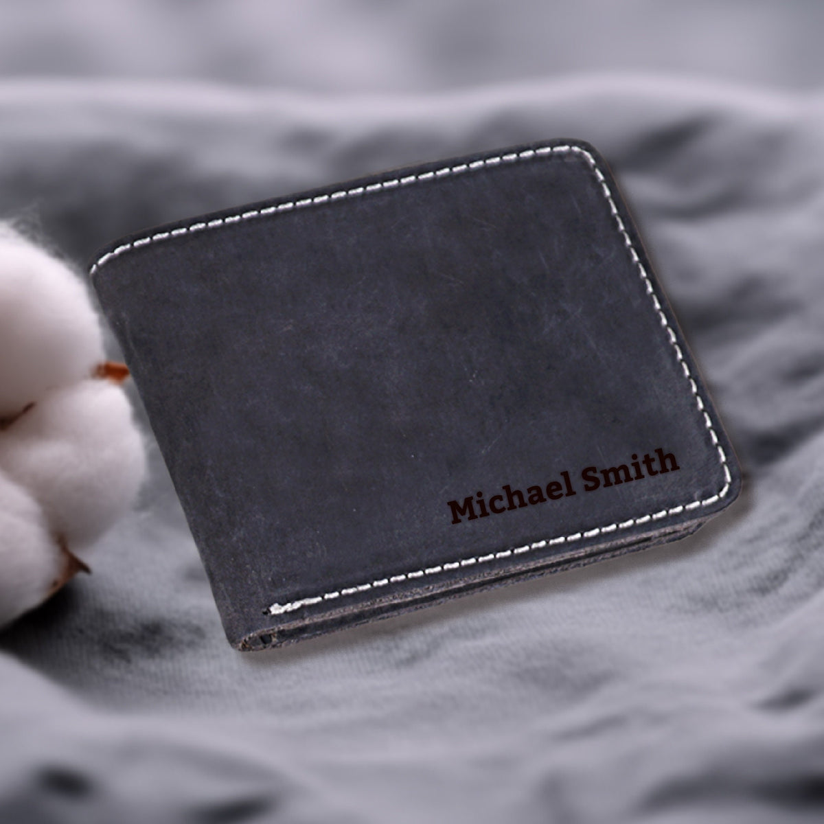 May include: A black leather wallet with white stitching and the name "Michael Smith" embossed in brown lettering.