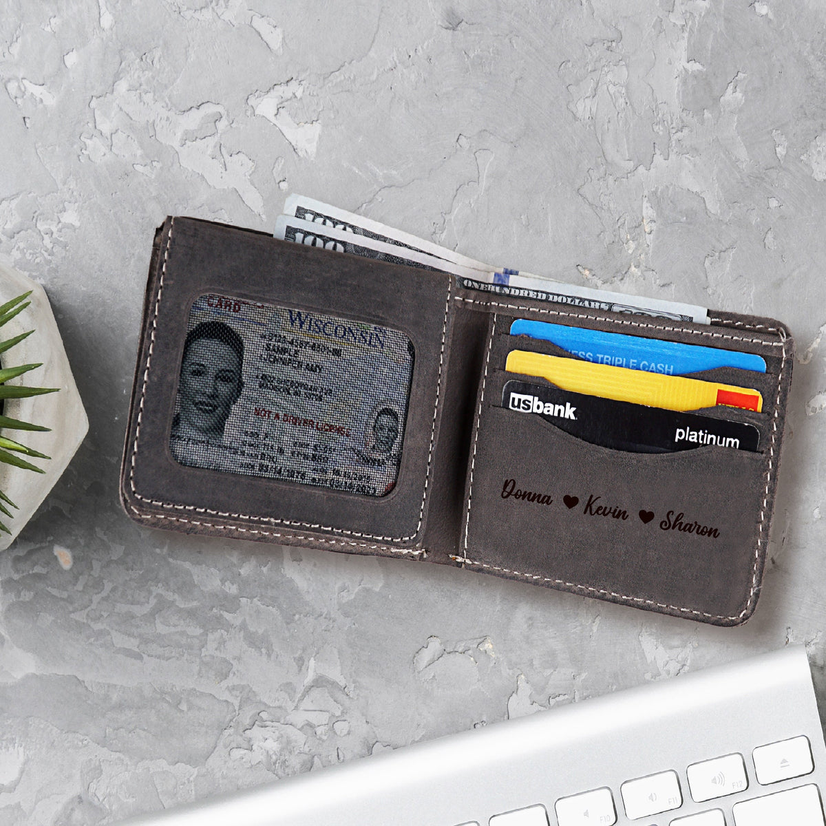 May include: A brown leather wallet with a window for an ID card. The wallet has a personalized inscription that reads "Donna ♥ Kevin ♥ Sharon".