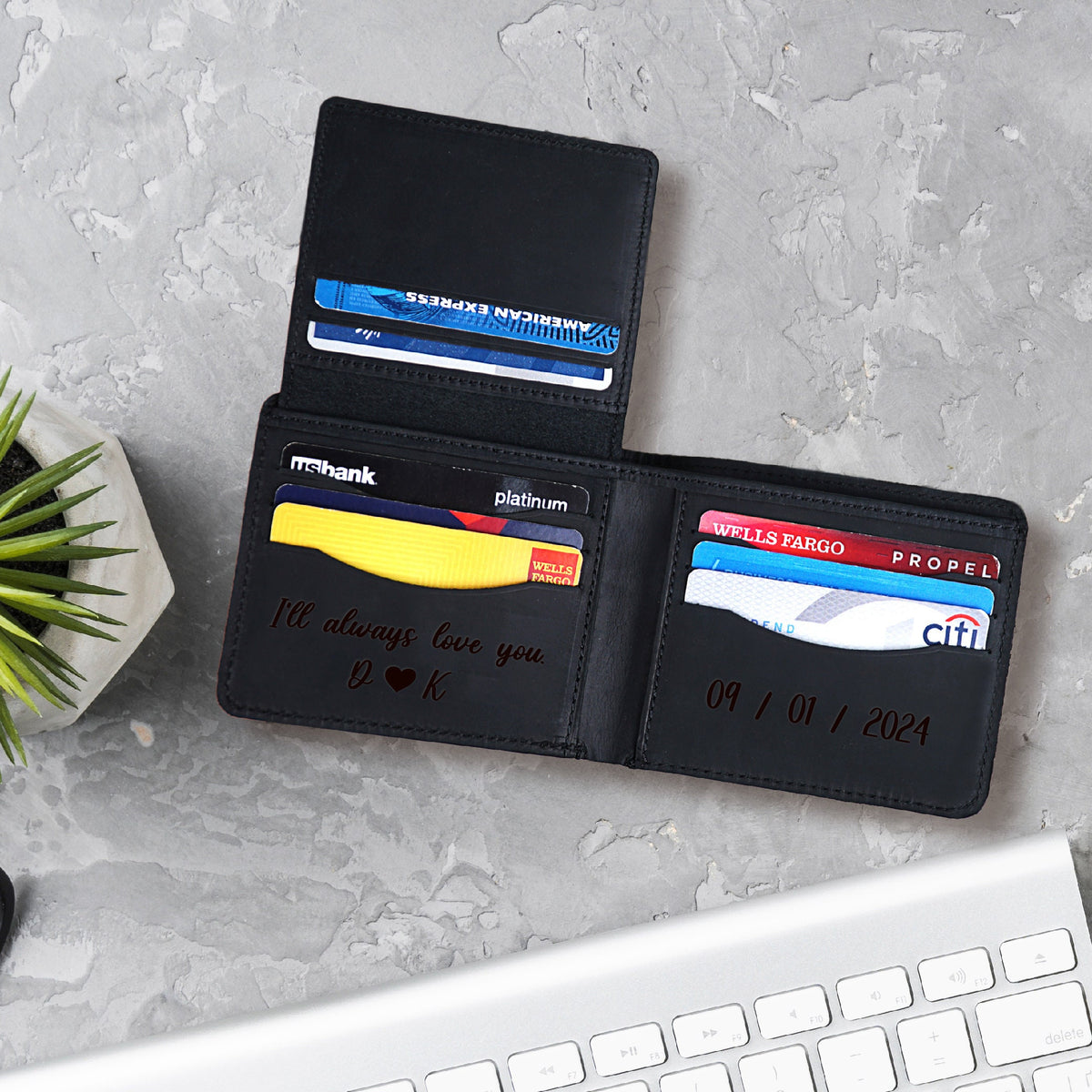 May include: A black leather wallet with a personalized inscription that reads "I'll always love you D♥K" and the date "09/01/2024". The wallet is open and has several credit cards inside.