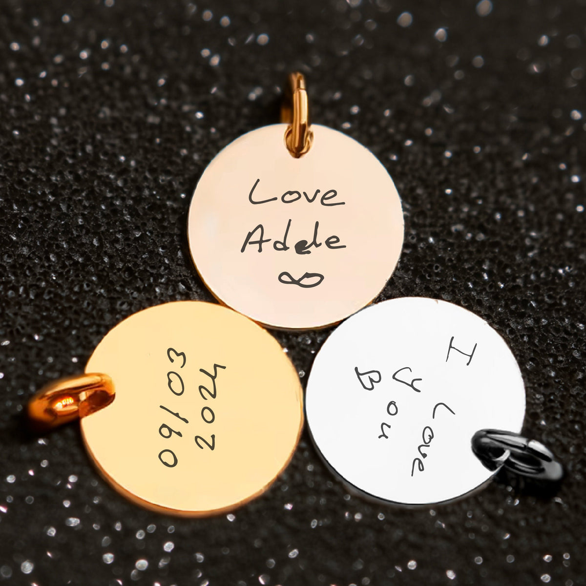 May include: Three gold and silver round charms with handwritten messages. The first charm says "Love Adele ∞", the second charm says "09/03/2024", and the third charm says "I love you"