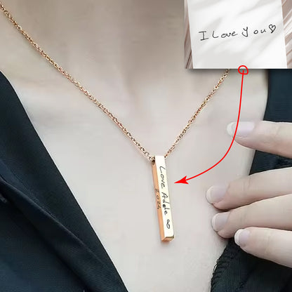 May include: A gold necklace with a vertical bar pendant engraved with the handwritten message "Love Adele 2021".