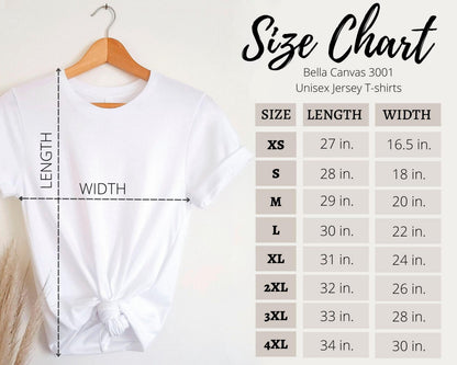 May include: A white Bella Canvas 3001 unisex jersey t-shirt hanging on a wooden hanger. The image includes a size chart with measurements in inches for sizes XS to 4XL. The chart lists length and width for each size.
