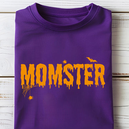 May include: A purple t-shirt with the word "MOMSTER" in orange, featuring a dripping font style. The design includes a spider web, a spider, and a bat, all in orange, creating a Halloween theme.