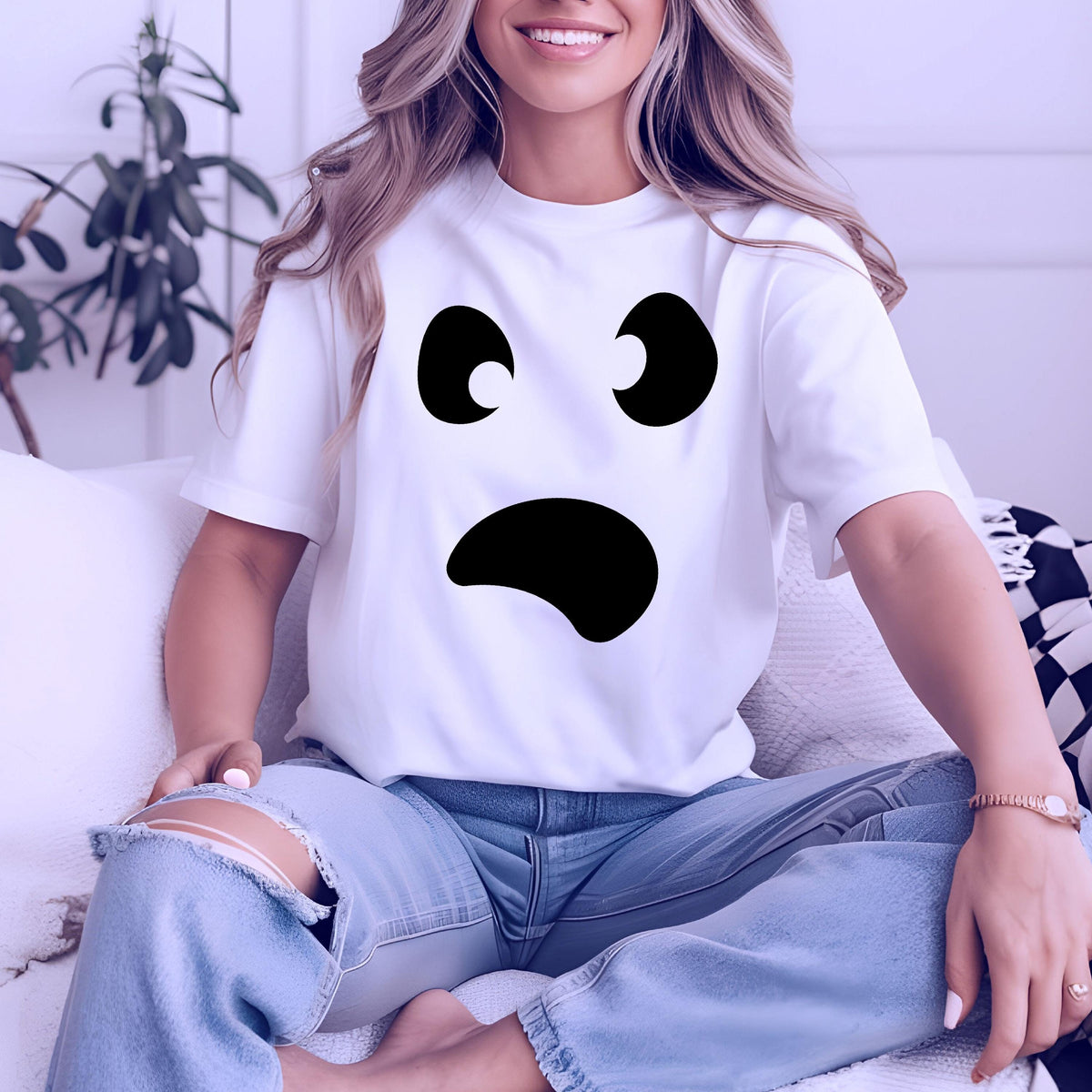 May include: White t-shirt featuring a black ghost face design. The graphic includes two curved eyes and a curved mouth, creating a surprised expression. The shirt is short-sleeved and appears to be made of a soft material.