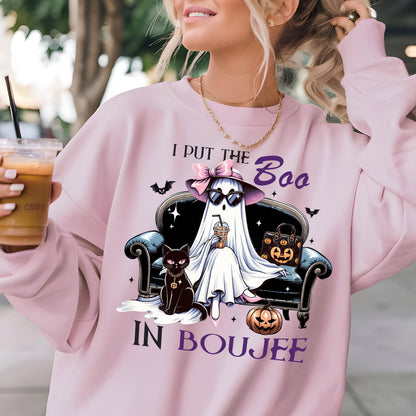 May include: A light pink sweatshirt featuring a graphic of a ghost wearing a hat and sunglasses, sitting on a sofa with a black cat, a pumpkin, and a handbag. The text reads I PUT THE Boo IN BOUJEE, surrounded by small bats and stars.