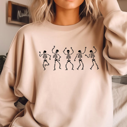 May include: Beige sweatshirt featuring a black graphic of five dancing skeletons. The skeletons are in various poses with their arms raised. The sweatshirt has a crew neck and long sleeves. The overall theme is Halloween.