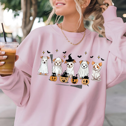 May include: A light pink sweatshirt featuring a Halloween-themed design. The graphic includes cartoon dogs dressed as ghosts, a witch, and bats, along with pumpkins and a broom. The sweatshirt has a crew neck.