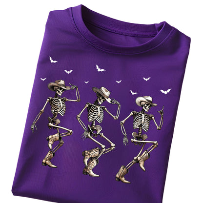 May include: A purple t-shirt featuring three dancing skeletons wearing cowboy hats and boots. White bat silhouettes are scattered across the top. The skeletons are in various dance poses, with detailed bone structures.