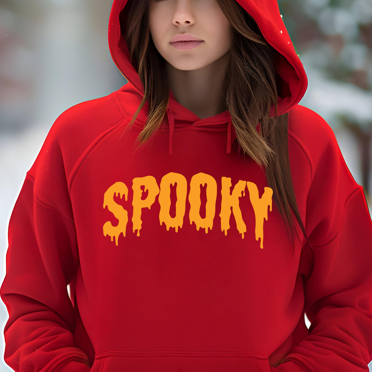 May include: A bright red hooded sweatshirt featuring the word SPOOKY printed in a yellow, dripping, liquid-like font across the chest. The garment includes a drawstring hood and long sleeves, providing a bold, solid-colored appearance.