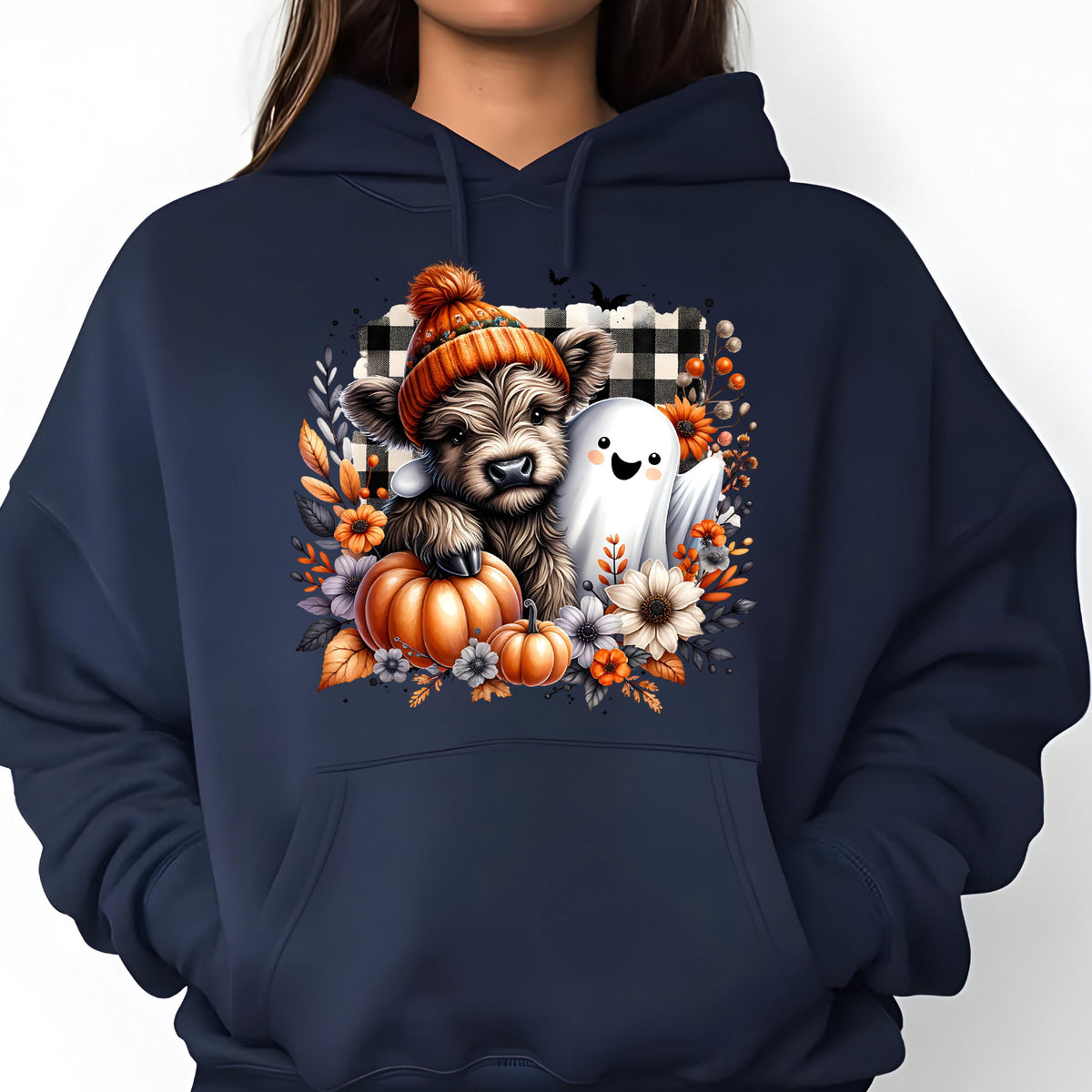 May include: A navy blue hooded sweatshirt featuring a graphic print of a fluffy highland cow wearing an orange knit beanie, accompanied by a small white ghost, pumpkins, and autumn flowers against a black and white buffalo plaid background.