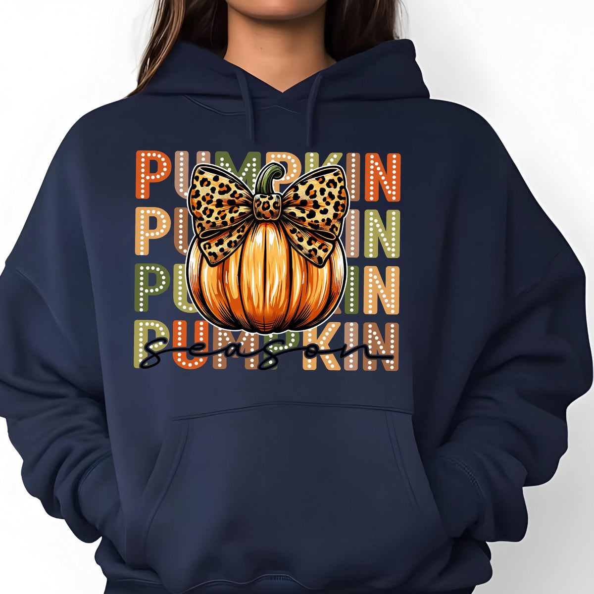 May include: Navy blue hoodie featuring a colorful graphic. The graphic includes the words "PUMPKIN SEASON" in a vertical arrangement, with a pumpkin and leopard print bow. The pumpkin is orange with green accents.