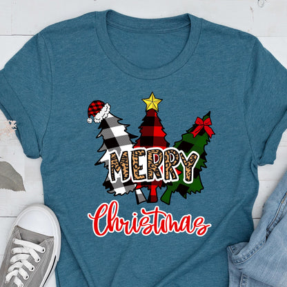 May include: A teal t-shirt featuring a graphic of three stylized Christmas trees in black and white buffalo plaid, red and black buffalo plaid, and green plaid. The word MERRY is in leopard print, and the word Christmas is in red script.