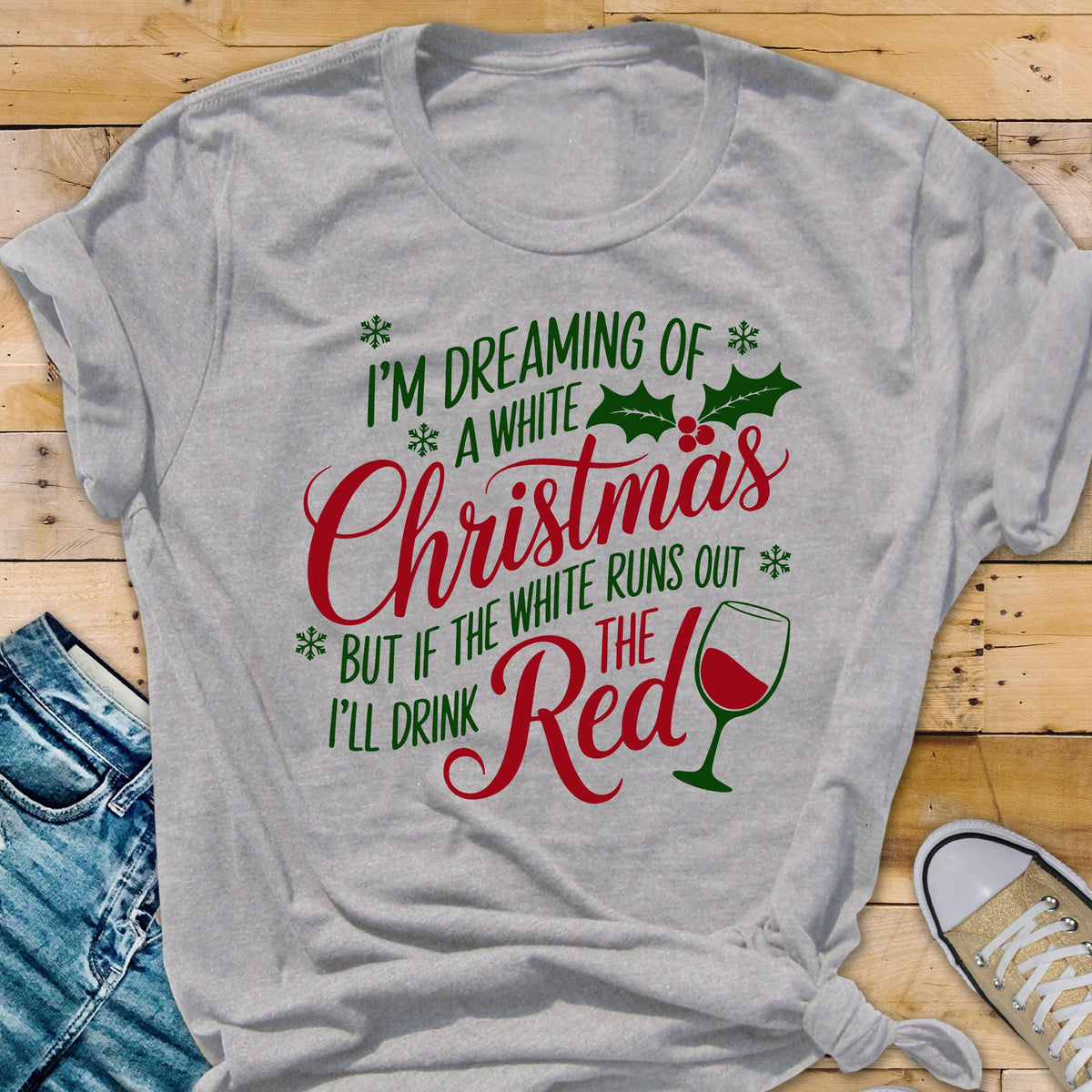 May include: A light gray t-shirt with the text "I'M DREAMING OF A WHITE Christmas BUT IF THE WHITE RUNS OUT I'LL DRINK THE Red" in green and red. A wine glass graphic is also included.