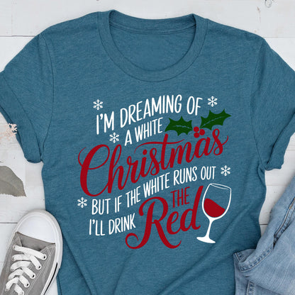 May include: Teal t-shirt with the text "I'M DREAMING OF A WHITE Christmas BUT IF THE WHITE RUNS OUT I'LL DRINK THE RED" in white and red. The design includes snowflakes, holly, and a wine glass.