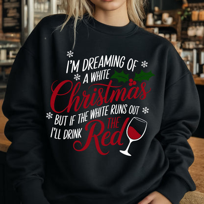 May include: A black long-sleeve sweatshirt featuring white and red text that reads I'M DREAMING OF A WHITE CHRISTMAS BUT IF THE WHITE RUNS OUT I'LL DRINK THE RED. The design includes white snowflakes, green holly leaves with red berries, and a wine glass.
