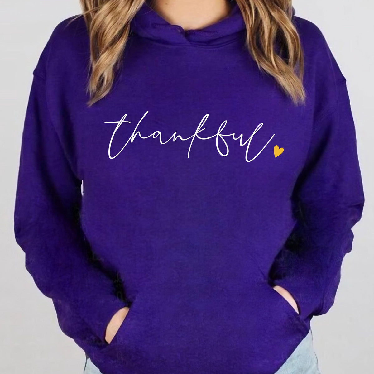 May include: Purple hoodie with a white cursive word "thankful" and a small yellow heart.