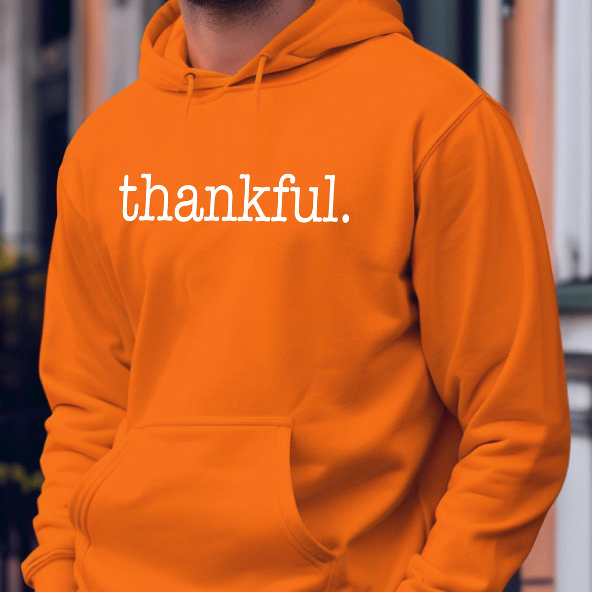 May include: Orange hoodie with a front pocket and a drawstring hood. The word "thankful" is printed in white across the chest. The hoodie is made of a soft material.