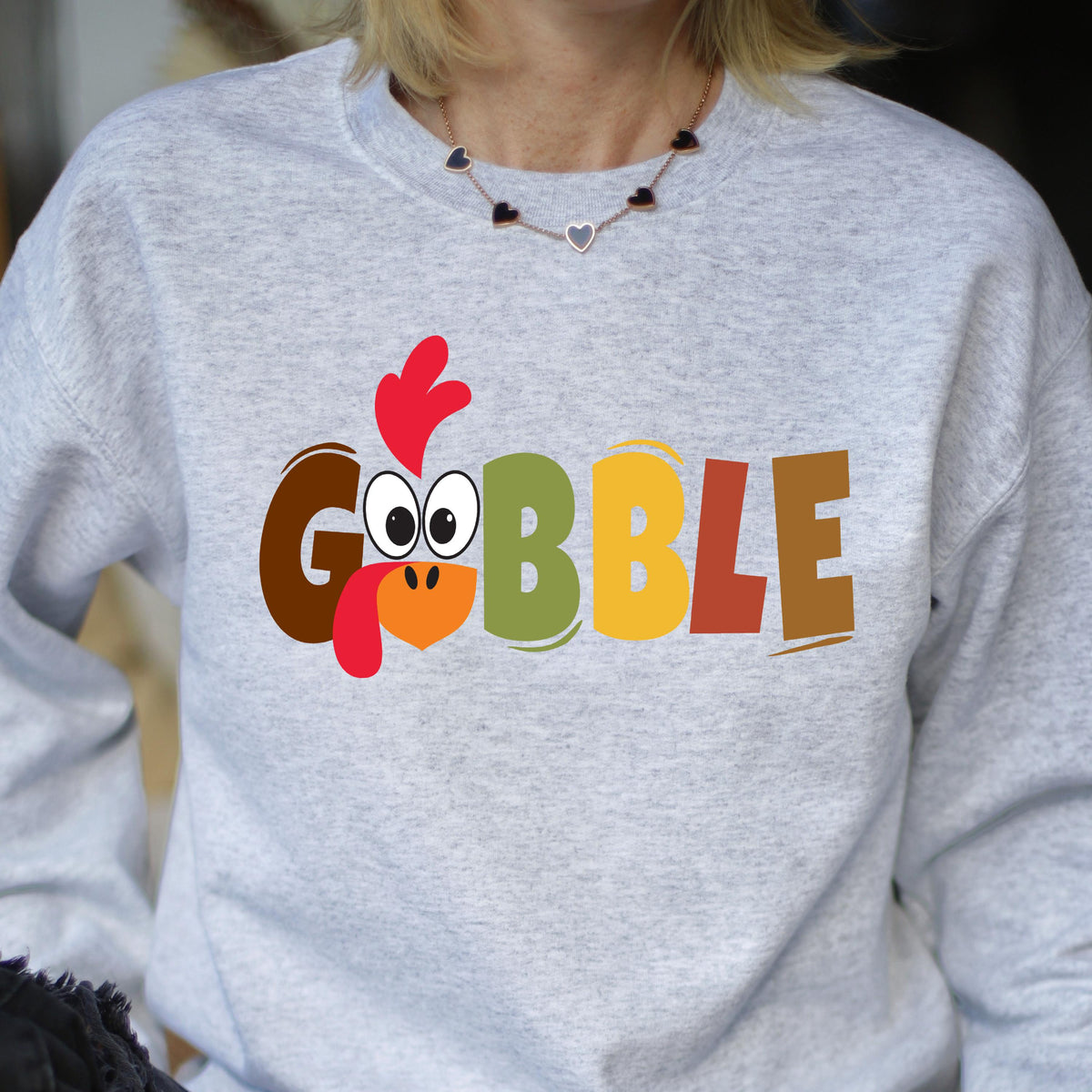May include: Gray sweatshirt with a colorful graphic of a turkey with the word "GOBBLE" printed on it.