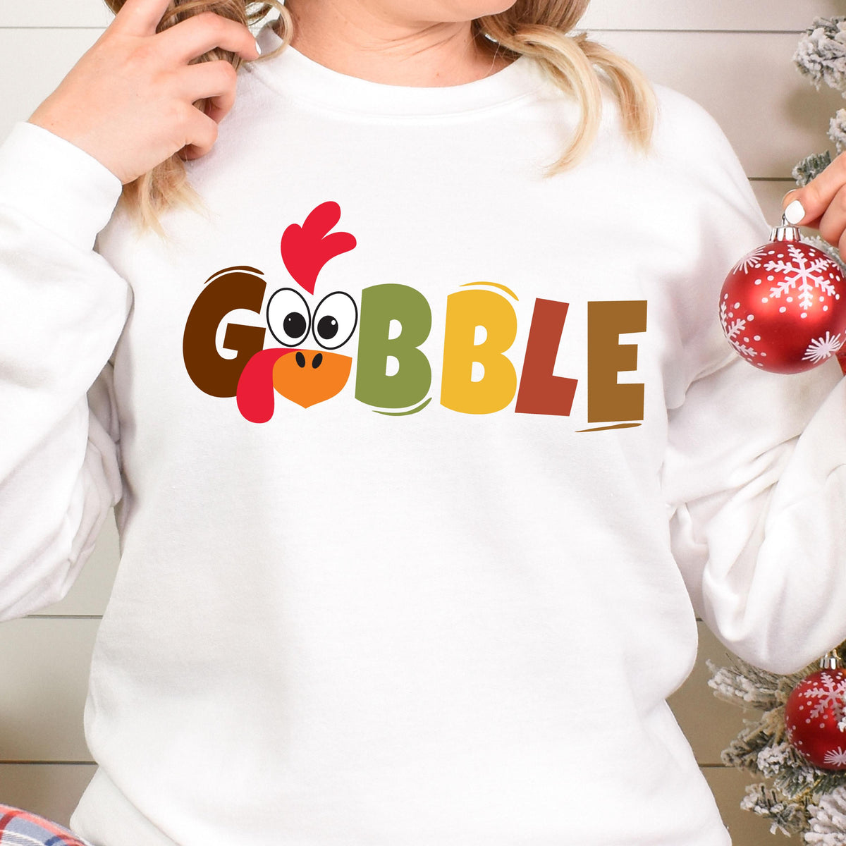 May include: White sweatshirt with a colorful "Gobble" graphic featuring a cartoon turkey head.