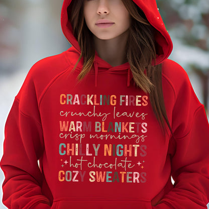 May include: Red hooded sweatshirt with a colorful graphic print that reads "Crackling Fires, Crunchy Leaves, Warm Blankets, Crisp Mornings, Chilly Nights, + Hot Chocolate +, Cozy Sweaters".