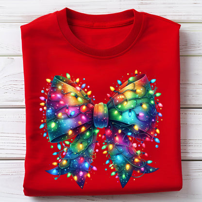 May include: A red sweatshirt featuring a vibrant, colorful bow design. The bow is adorned with a string of Christmas lights in shades of blue, green, yellow, and red. The design is centered on the front of the sweatshirt.