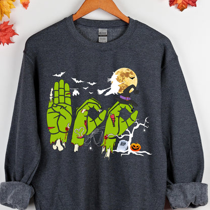 May include: Dark gray sweatshirt with a Halloween-themed design. The design features green zombie hands spelling out the word "RIP", a full moon, bats, a witch, and a jack-o'-lantern. The sweatshirt is hanging on a wooden hanger.