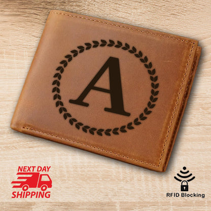 May include: A brown leather wallet with a monogrammed initial "A" in a wreath design. The wallet has RFID blocking technology.
