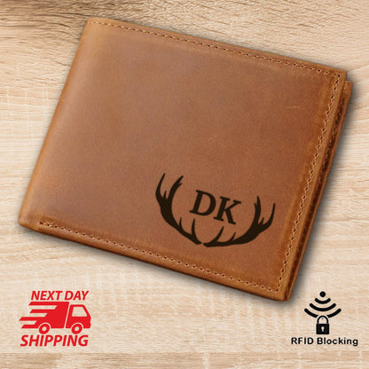 May include: A brown leather wallet with the initials "DK" and a deer antler design. The wallet has a stitched border and a textured appearance. The image also includes a "Next Day Shipping" graphic and an "RFID Blocking" icon.