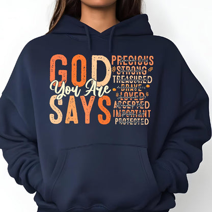 May include: Navy blue hoodie with the text "GOD YOU ARE SAYS" in orange and white. The text is surrounded by smaller text in orange, including "Precious", "Strong", "Treasured", "Brave", "Loved", "Accepted", "Important", and "Protected".